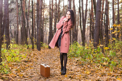 Full length of woman standing in forest