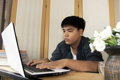 Portrait of teenage girl sitting on table