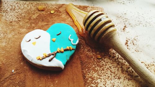 High angle view of cookie and honey dipper on table