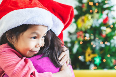 Cute girl hugging sister during christmas
