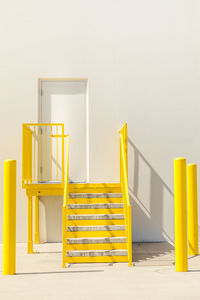 Yellow staircase against white wall at a warehouse entrance