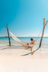 Person on beach against clear sky