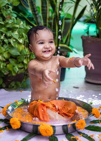 Cute toddler baby boy bathing in decorated bathtub at outdoor from unique perspective