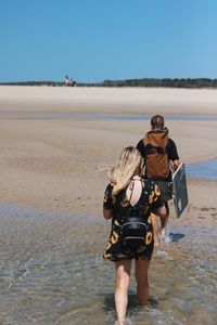 Rear view of couple walking on beach