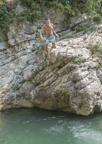 Woman standing on rock formation in water