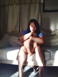 Portrait of a girl sitting on bed at home