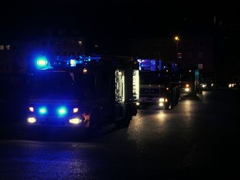 Cars on illuminated street at night
