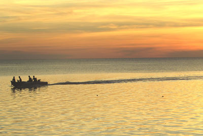 Silhouette boats in sea against sky during sunset