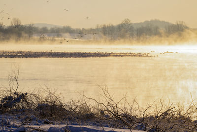Scenic view of lake against sky during winter
