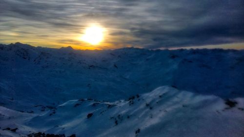 Scenic view of snowcapped mountains against sky during sunset