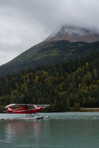 Scenic view of lake by mountain against sky