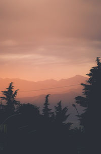 Scenic view of silhouette mountains against orange sky