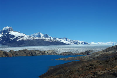 Scenic view of snowcapped mountains against clear blue sky