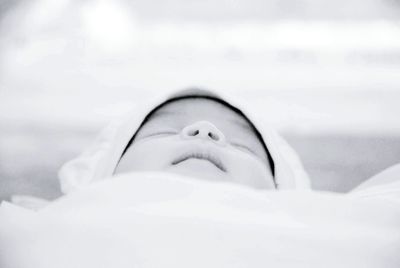 Close-up of woman sleeping on snow covered bed