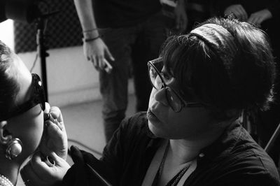 Close-up of make-up artist applying lipstick on woman