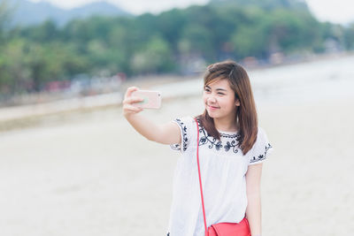 Girl taking selfie at beach