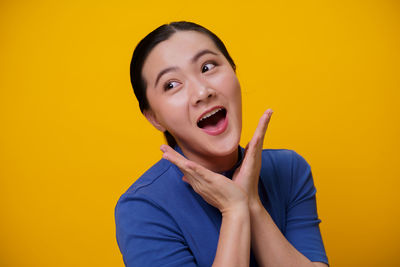 Portrait of mid adult man against yellow background