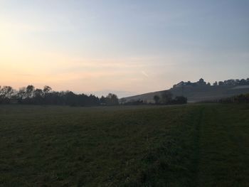 Scenic view of field against sky at sunset