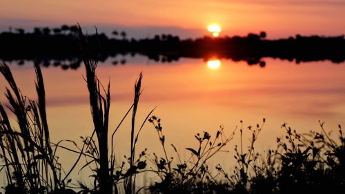 Scenic view of lake against romantic sky at sunset