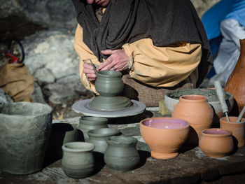 Midsection of woman molding shape on pottery wheel