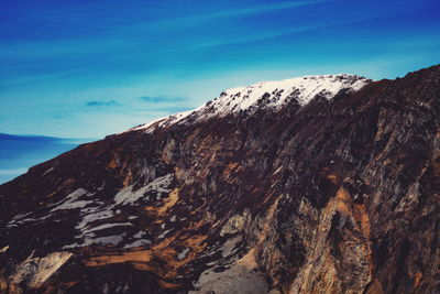 Scenic view of sea and mountains against blue sky