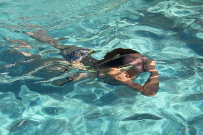 High angle view of shirtless man swimming in pool