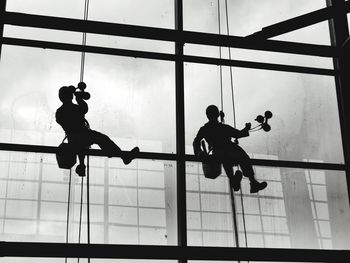 Low angle view of silhouette men on glass window