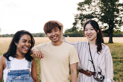 Cheerful friends standing together at park