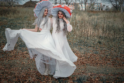 Woman with umbrella standing on land