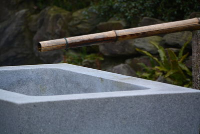 Bamboo pipe above stone container in garden