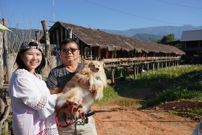 Portrait of happy friends outside house against building