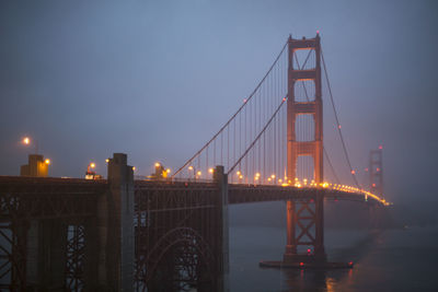 Golden gate bridge over sea against sky during foggy weather