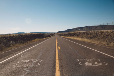 Road by landscape against clear sky