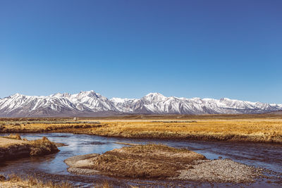 Scenic view of snowcapped mountains against clear blue sky