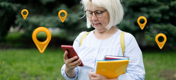 Midsection of woman holding drink with mobile phone