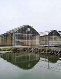 Reflection of building in lake against clear sky