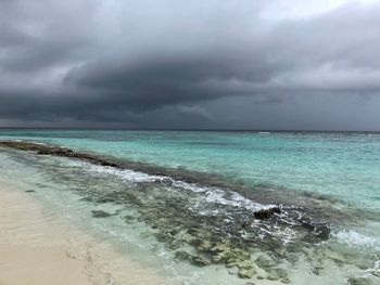 Scenic view of sea against storm clouds