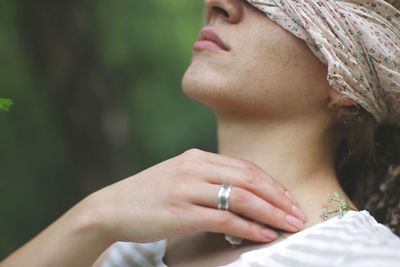 Midsection of woman holding flowers while sitting outdoors