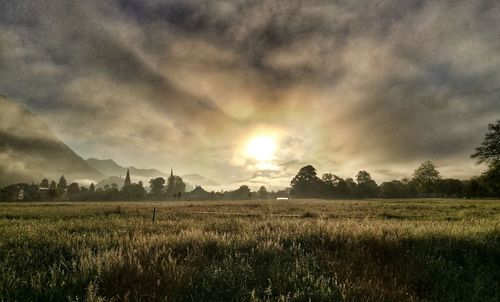 Scenic view of field against cloudy sky