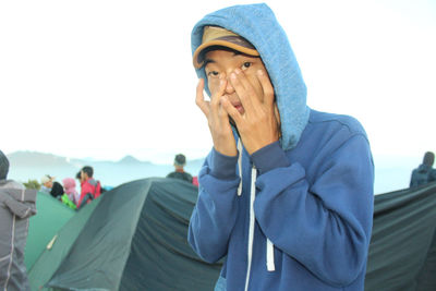 Portrait of man standing against sky