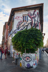 Graffiti on wall in city against sky