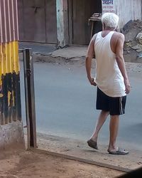 Rear view of woman standing against building