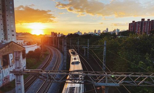 Railroad tracks against sky during sunset