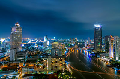 Illuminated buildings in city against sky at night