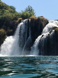 Scenic view of waterfall against clear sky