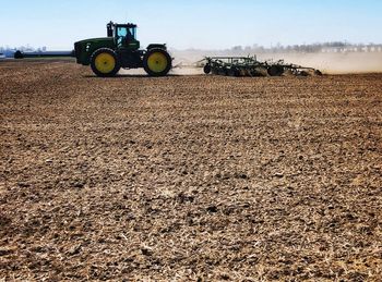 Tractor on agricultural field against sky