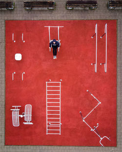 Aerial view of one man on red street workout field