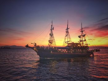 Silhouette ship in sea against sky during sunset