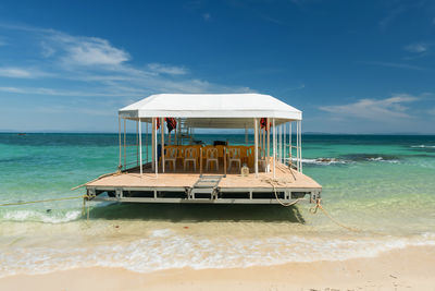 Lifeguard hut on beach against sky