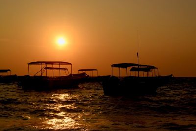 Silhouette boat in sea against sky during sunset